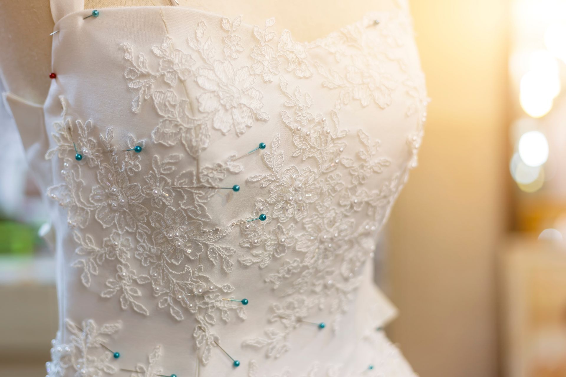 Close-up of fitted lace wedding gown with tailoring details