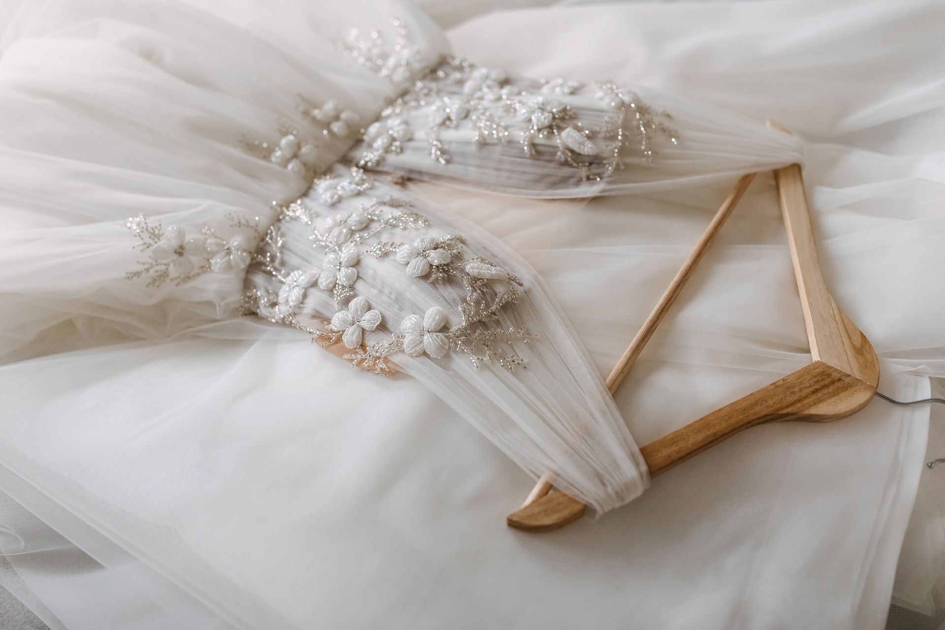 Seamstress adjusting delicate lace on a bridal gown