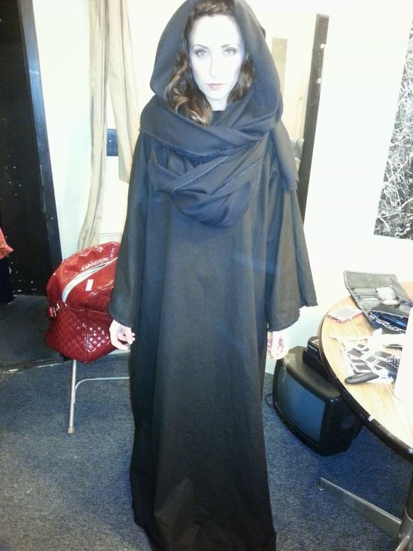 Woman wearing long black hooded cloak