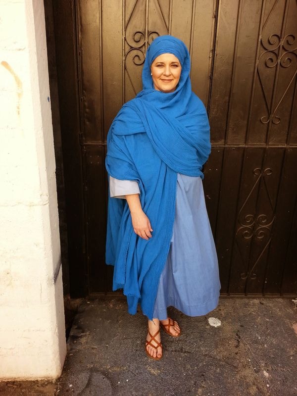 Woman wearing blue hijab at ornate door